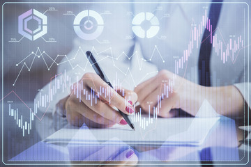 Double exposure of hands making notes with forex chart huds. Stock market concept.