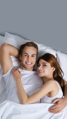 Happy young couple on the bed