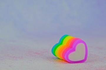 Colorful heart-shape erasers in arrangement for Valentine's day as background with copy space on the left.