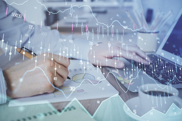 Multi exposure of stock market graph with man working on laptop on background. Concept of financial analysis.