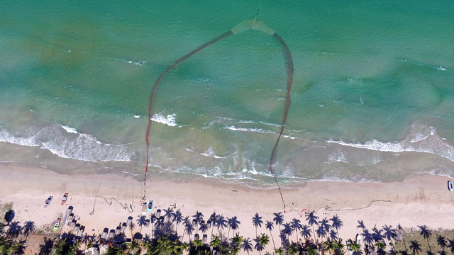 Traditional fishermen in Uppuveli beach, Sri Lanka. They are pulling net from beach. Overfishing make this fishing technique less and less profitable. Nilaveli beach in Trincomalee, Sri Lanka