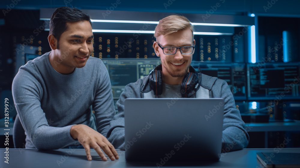 Aufkleber gaming software delevoper talks with it enginer, discussing project desing shown on laptop. in the b