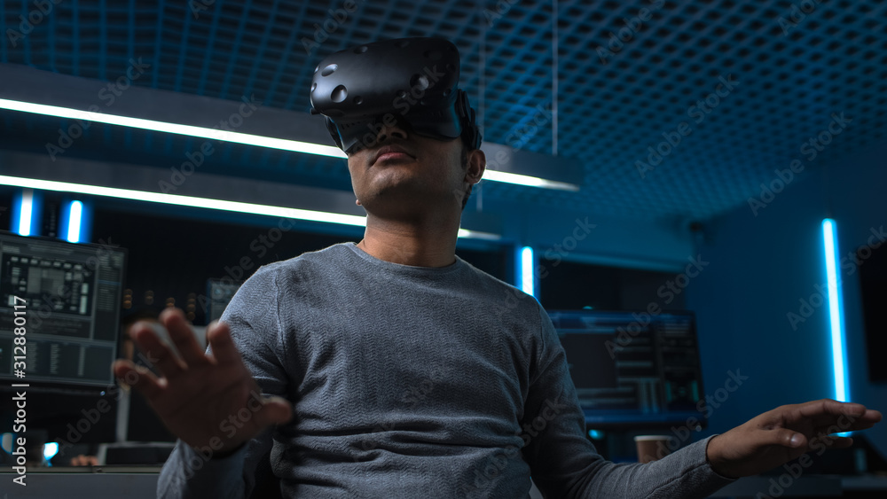 Aufkleber Software Delevoper Wearing Virtual Reality Headset Gesturing with His Head, Developing and Programming VR Game or Application. In Background Technology Developing Studio with Computers and Monitors