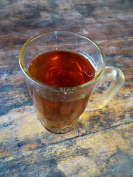 A glass of hot sweet tea (teh manis) on the wooden table