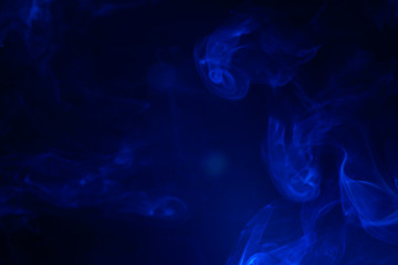 Blue smoke on black background.
