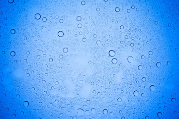 Rain droplets on blue glass background, Water drops on blue glass.