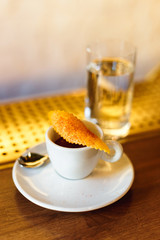 Minsk, Belarus - 03.19.2018: a cup of ILLY brand espresso, garnished with an orange peel covered with cinnamon, a glass of water