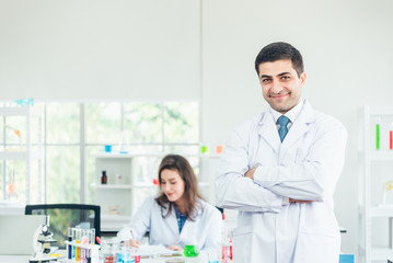 Smiling scientist leaning against the whiteboard in laboratory