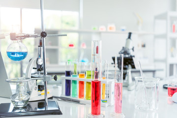 Chemical laboratory glassware with various colored liquids on table