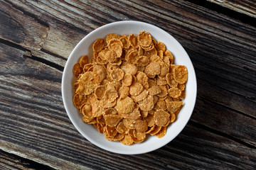 White plate with healthy cereal breakfast on a wooden surface.