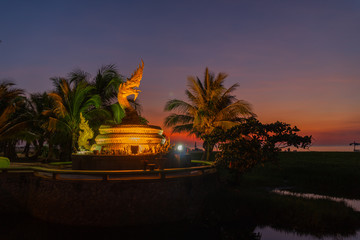 sunset behind golden dragon statue on Karon beach Phuket Thailand