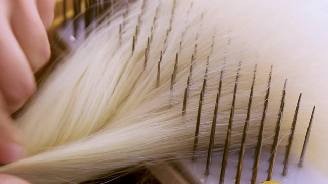 Hair combing when creating a wig. Factory wig production process
