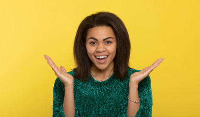 Young beautiful african american girl laughing . Portrait. Yellow background.