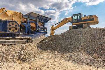 Excavator moving stone and rock for gravel transformation