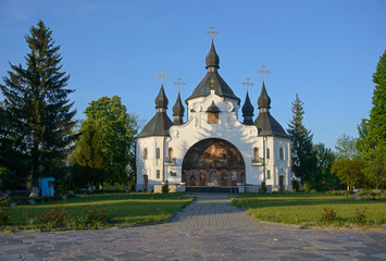 Fototapeta na wymiar St. George's Church in Plyasheva surrounded with lush green trees