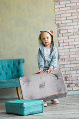 little girl carries a suitcase