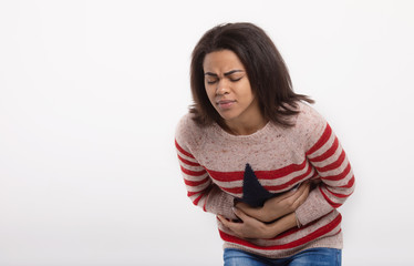 woman with stomach abdomen pain having bad aches isolated on white background. Face expression