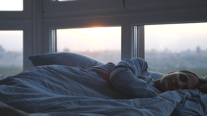 Beautiful romantic brunette woman sleeping on bed by the window