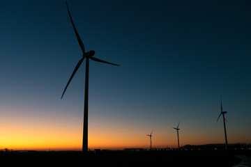 Windturbines are silhouetted against the twilight sky