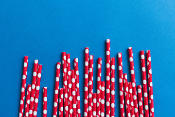 Red cocktail straws on a blue background