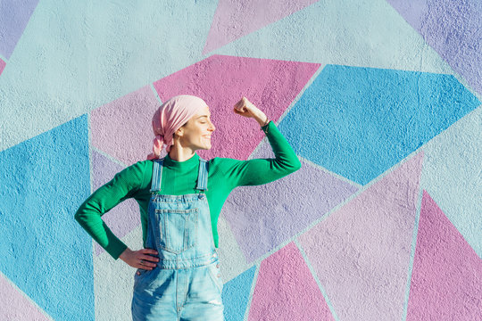 Portrait of woman with pink headscarf, has cancer. Show the arm as a signal of strength