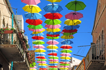Obraz na płótnie Canvas Colored Umbrellas in blue sky in Jerusalem Israel
