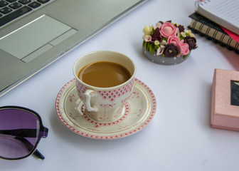 Coffee in the office, close-up of the desk with beautiful decorated cup with hot beverage, business concept