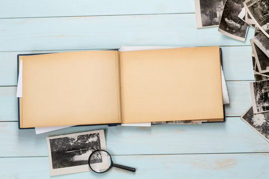 Old photo album with photos on a wooden table.Mockup free.Copy space.
