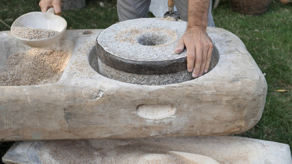 Man is preparing rye into grinding for wholemeal flour at quern
