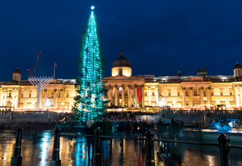 London, UK/Europe; 20/12/2019: Night view of The National Gallery and a Christmas tree in Trafalgar Square, London. Long exposure shot with blurred people walking.
