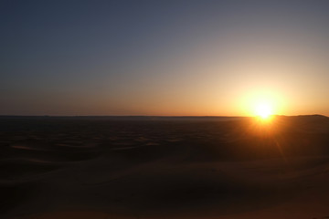 Fototapeta na wymiar Sun rising over Erg Chebbi dunes Sahara desert at dawn. Morning sunrise time in Merzouga, Morocco.