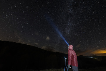 man with headlamp taking photos of the starry sky
