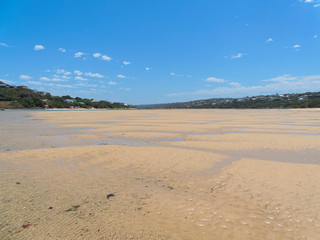 Rippled sand and meandering tide pools on the wide expanse of the Bushman's River estuary at low tide at Kenton on Sea, South Africa.
