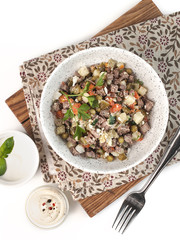 winter vegetable salad olivier with meat with mayonnaise on a white background isolated top view