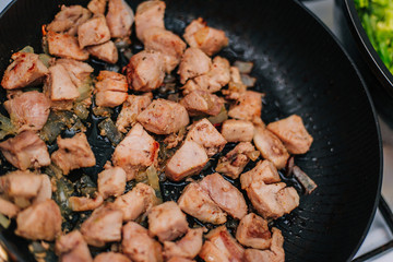 Cooking meat in a pan with onions. Fried chicken. Diced meat