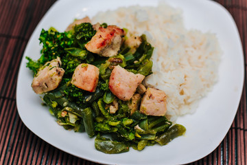 White plate with broccoli and beans stewed vegetables with chicken.