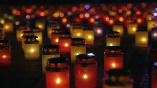 Many burning candles - concept of memory of the dead. Feeling of sadness, pain and suffering. Laterns represent the memories of loved ones. Mass candle light vigil. Focus from foreground to background