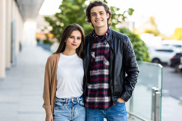 Couple of tourists taking a walk in a city street sidewalk in a sunny day