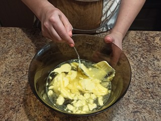 confectioner mixing water with butter in bowl