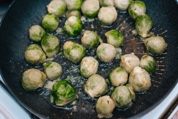 Brussels sprouts in the pan. Fried cabbage in butter
