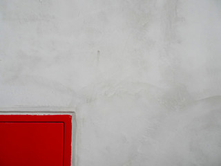 Red hydrant metal box and concrete finished wall