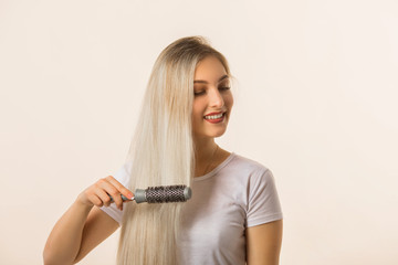 beautiful young woman on a beige background with her hair with a comb