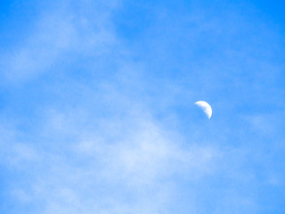 cloudy sky in day time with haft moon, blue sky background