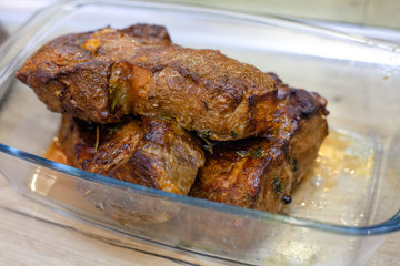 Exquisite baked meat in a glass transparent bowl. Juicy roast beef, delicious meat, traditional food. Steak.  Dinner for men. 