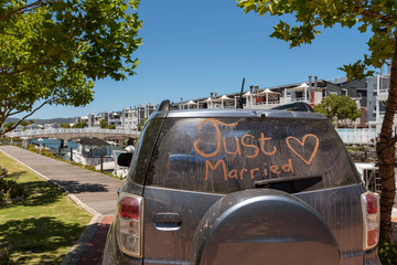 South Africa. December 2019. Just married sign with a heart painted on the rear window of a car.