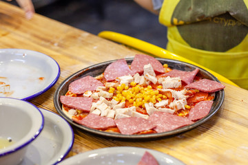 Children cooking pizza. Photo of children hands cooking Italian food. Process of cooking pizza by children in the master class. 