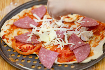 Children cooking pizza. Photo of children hands cooking Italian food. Process of cooking pizza by children in the master class. 