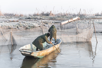 two fishermen and nets at a deep temperature minus