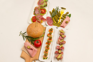 Assortment of canapes with salmon, bacon, cheese, pickles on a white background, top view,.