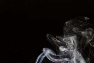 Abstract smoke background with copy space on black background. Blue-white smoke rising from the incense stick